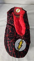 Top view of the black slipper with red lightning designs and embroidered Flash logo showing plush red interior