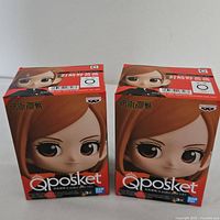 Front view of two Qposket Nobara Kugisaki mini figure boxes showing character face artwork and branding.