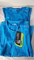 Pair of blue CEP Wingtech short sleeve shirts, folded with tags attached, front view.