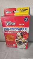 Sealed 2025 Topps Heritage Major League Baseball blaster box in red and yellow packaging showing key branding and player image.