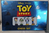 Box with four Toy Story character chess pieces (Jessie, Buzz Lightyear, Bo Peep, Woody) visible through window