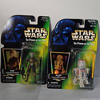 Front view of 4-Lom and R5-D4 Star Wars action figures sealed in original Kenner packaging, showing details and logos.
