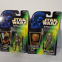 Photo of two Star Wars action figures in sealed blister packaging showing 4-LOM and Grand Moff Tarkin from The Power of the Force series.