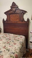 Full view of carved headboard attached to bed