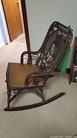 Side view of entire wicker rocking chair showing rockers and wear