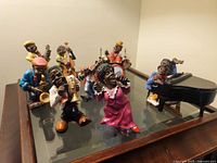 Group shot of eight jazz musician figurines with separate piano and drum kit displayed on table