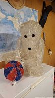 Front view of clear woven lighted polar bear holding red/blue ball, plug visible