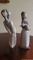 Both Lladró figurines standing on table