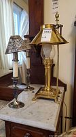 All three lamps grouped: brass Orient Express lamp and two EPNS candlestick lamps