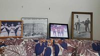 Overall view of four framed sports photos on couch