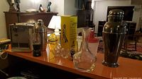 Group shot of all items on countertop: appliance, shakers, glasses, decanter, yellow box