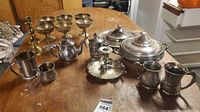 Entire lot displayed on table showing variety of silverplate and brass pieces
