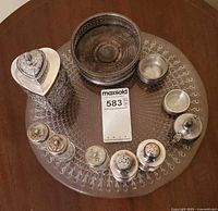 Overview of glass platter with silver-plated containers and glass shakers