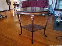 Full view of oval two-tier side table showing legs and lower shelf