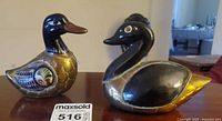 Both brass enamel duck figurines side by side