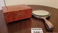 Music box and mirror on table, front view of box clasp
