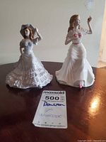 Both figurines side by side with auction tag