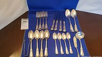Full layout of flatware set on blue cloth