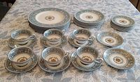 Full set on table showing stacks of dinner and side plates, cups with saucers