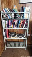 Full view of bookcase showing three shelves, spindle rail, paint finish and books