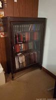 Full view of glass-front bookcase against wall