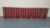 Front view of all 18 red-bound volumes lined up side by side