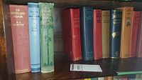 Spines of eight cloth-bound hardcovers including "In Scotland Again" and others
