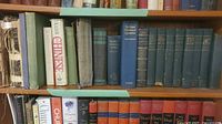 Shelf showing assorted vintage cloth hardbacks in various colours