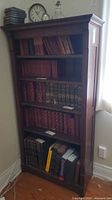 Front view of wooden bookcase filled with books