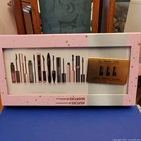 Front view of the sealed beauty box displaying mascara samples with a pink and white design with gold star details.
