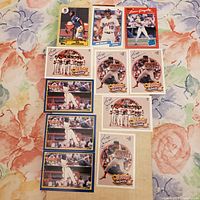 Nine vintage Major League Baseball sports cards laid out on a floral patterned cloth. Cards include images of Bo Jackson, Juan Gonzalez, team group shots and individual player action shots. Cards are ungraded and appear in near mint condition.