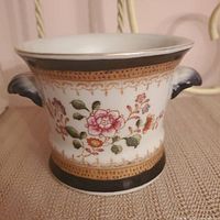 Front side of porcelain vase showing full floral design and ornamental border.