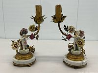 Front view showing both lamps, cherubs, floral details, marble bases