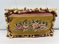 Front view showing tapestry design and pom-pom trim