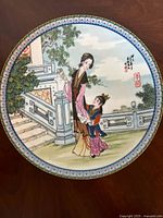 Front side of the 8-inch porcelain plate showing detailed Chinese art of a woman and child with floral and architectural background.