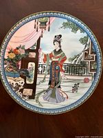 Front view of the porcelain plate showing detailed traditional Chinese woman illustration with a blue border.