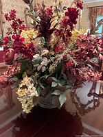 Front and full view of silk floral arrangement with varied flowers and foliage in ceramic vase