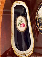 Full view of the elongated porcelain tray showing the navy blue inset, white border, floral artwork, and gold detailing.