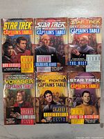 Front cover of all six Star Trek Captain's Table books showing various captains from different series.