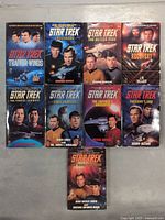 Front covers of 9 Star Trek paperback novels showing characters and titles.