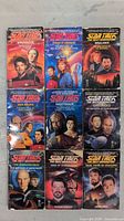 Front view of nine Star Trek: The Next Generation VHS tapes arranged in three rows of three with cover art visible.