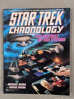 Front cover of the Star Trek Chronology book showing Star Trek ships and characters in space.