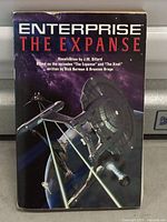 Front cover of the paperback novel showing title, author, and starship image.