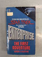 Front cover of the Star Trek novel titled 'Enterprise The First Adventure' by Vonda N. McIntyre showing series logo, author, and an image of the Enterprise starship.