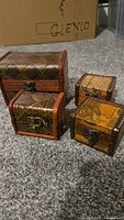 Four wooden trinket boxes of two sizes on carpet
