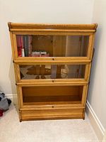 Front view of assembled three-tier oak barrister bookcase showing missing bottom glass