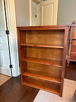 Front full view of the pine bookshelf showing all three shelves with natural wood finish.