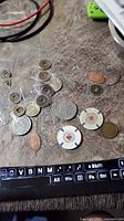 Assorted coins and tokens spread on tabletop