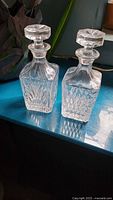 Both crystal decanters front view showing cut patterns and stoppers