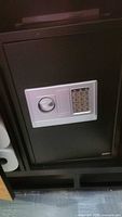 Front view of black safe showing keypad and knob